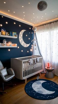 a baby's room decorated in blue and white with stars on the ceiling, moon - shaped rugs, and a crib