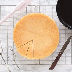 a cake sitting on top of a white counter next to a knife and spatula