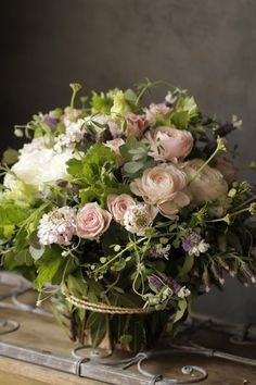 a basket filled with lots of flowers sitting on top of a table