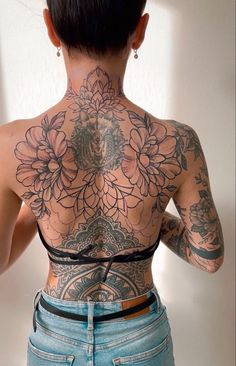 the back of a woman's body with tattoos on her upper and lower half