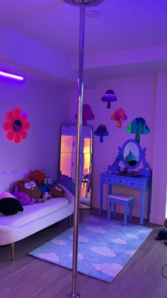 a room with a bed, table and mirror in it at night time is lit up by purple lighting