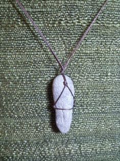 a rock with a wire wrapped around it sitting on a green cloth covered tablecloth