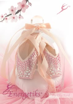 a pair of pink ballet shoes sitting on top of a pillow