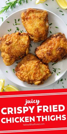 crispy fried chicken thighs on a white plate with lemons and herbs in the background