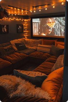 a living room filled with lots of couches covered in blankets and pillows next to a flat screen tv