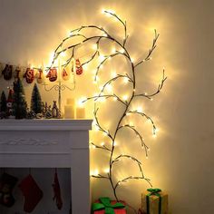 a christmas tree with lights and presents on the mantle in front of a white fireplace