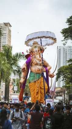 a large statue of an elephant is in the middle of a crowd