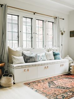 a living room filled with lots of furniture and pillows on top of a white couch