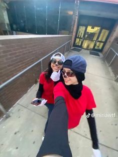 two women taking a selfie in front of a brick building