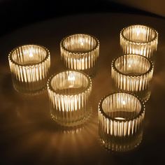 five lit candles sitting on top of a table