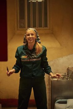 a woman standing in front of a sink with her hands out and holding a knife