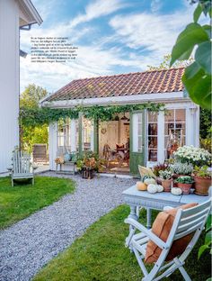 a small white house sitting on top of a lush green field