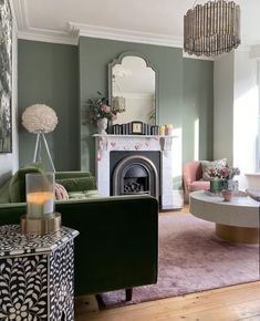 a living room filled with furniture and a fire place under a chandelier over a fireplace