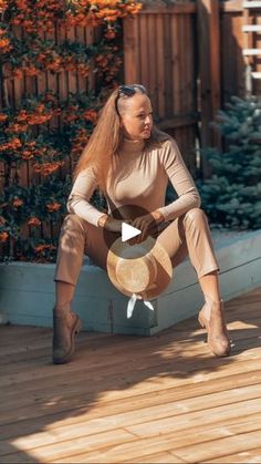 a woman sitting on top of a wooden deck