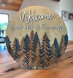 a wooden sign that says welcome to our next of the woods