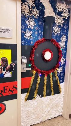 an office cubicle decorated for christmas with a fake train on the wall and snowflakes