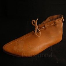 a pair of brown leather shoes on a black background