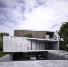 two cars are parked in front of a concrete building that has been designed to look like a house