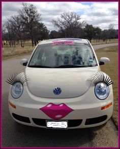 a white car with pink lips and eyelashes painted on it