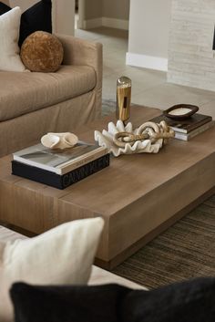 a coffee table with books on it in a living room