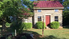 an old log house with a red roof