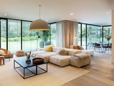 a living room filled with lots of furniture and large glass doors leading to an outside patio