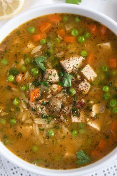 a bowl of soup with tofu, peas and carrots