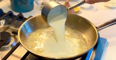 someone is pouring milk into a pan on the stove