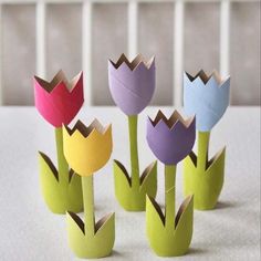 four paper tulips sitting on top of a white table