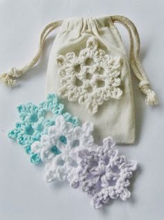 three crocheted flowers in a drawstring bag