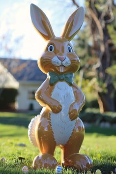 a brown and white rabbit statue sitting in the grass