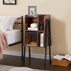 a small wooden book shelf next to a bed