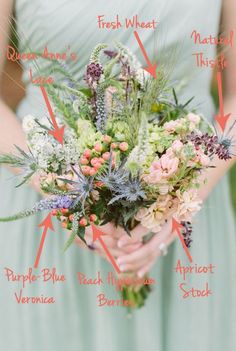 a woman in a green dress holding a bouquet of flowers and greenery on her wedding day