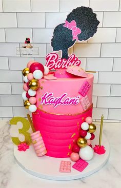 a birthday cake with pink and gold decorations on the top is decorated with an afro woman's head