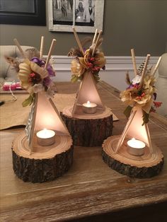 three candles are sitting on top of wood slices