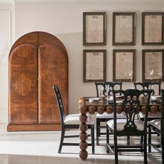 the dining room table is surrounded by chairs and framed pictures on the wall above it