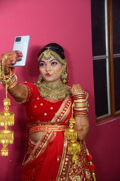 a woman dressed in red and gold holding a cell phone