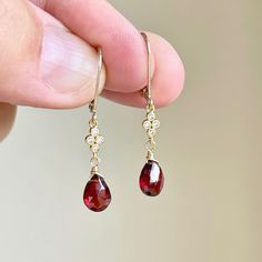 Garnet Earrings, January Birthstone, Red Teardrop Dangle Earrings, Minimalist Earrings Gold or Silver, Dainty Garnet Jewelry, Gift for women These precious delicate earrings feature vivid dark red garnet teardrops adorned with a white topaz connector in either gold filled or sterling silver. The earrings are suspended from lever back ear wires in the finish of your choice. These earrings are very feminine and subtle, perfect for every day. These make a perfect fall earring, or a gift for a women Garnet Jewelry Earrings, Garnet Earrings Drop, Gold And Red Earrings Dangle, Gold And Garnet Jewelry, Red Teardrop Earrings, Fall Inspired Jewelry, Garnet Earrings Gold, Gold Red Jewelry, Red And Gold Earrings