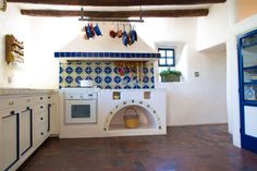 an oven in the middle of a kitchen with pots and pans on the wall