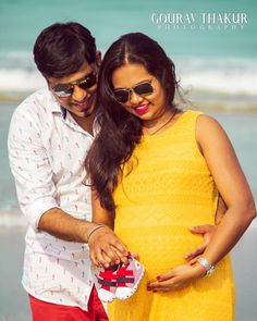 a man and woman standing next to each other on the beach