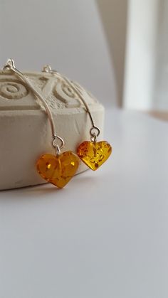 ❤ The Amber Heart earrings - are not just a piece of jewelry, but also a symbol of love, protection, and hope. The warm, golden-brown hues of Baltic Amber have been prized for centuries for their beauty, and believed to have powerful healing properties. These beautiful heart shaped earrings are made of genuine cognac & lemon Baltic Amber stones.  ❤ Minimalistic style earrings are small - the amber stone diameters:  1 x 1 cm (0.39 x 0.39 inches), the silver sterling 925 wire part lenght is 2.5 cm (0.98 inches). ❤ Such jewelry is always a perfect gift for every woman and for any occasion. Especially amber stones add luxury and romance to the whole style & make it look more exclusive, because every amber stone is unique. These earrings perfectly match casual or formal style. Cognac amber earr Amber Dangle Earrings As Gift, Round Earrings With Heart Charm As A Gift, Handmade Heart Cut Earrings As Gift, Handmade Heart Cut Earrings For Gifts, Amber Pierced Earrings As A Gift, Anniversary Sterling Silver Earrings With Heart Charm, Nickel Free Double Heart Earrings As Gift, Sterling Silver Heart Charm Earrings As Gift For Her, Amber Dangle Earrings For Gift