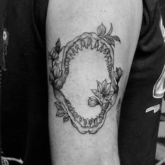 a black and white photo of a man's arm with a shark tattoo on it