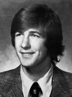 an old black and white photo of a man in a suit smiling for the camera