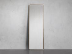 an empty mirror on the wall in front of a gray background with no one around it