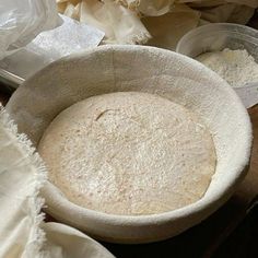 an uncooked pie crust in a bowl on a table with other baking supplies