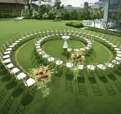 a circular lawn with chairs and flowers in the center