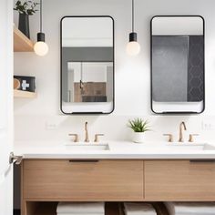 a bathroom with two sinks and mirrors above them