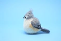 a felt bird sitting on top of a blue surface