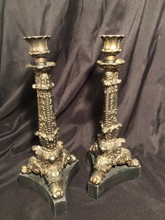 two gold candlesticks sitting on top of each other