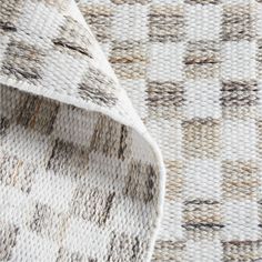 the texture of an upholstered rug with brown and white squares on it, as seen from above